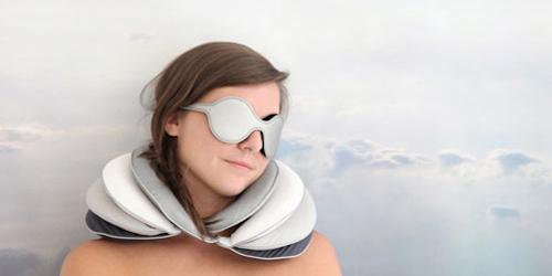 Girl wearing an eye mask and using travel pillow