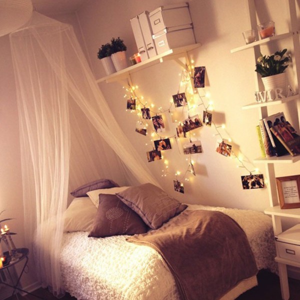 Purple canopy bed dorm room with hanging lights.
